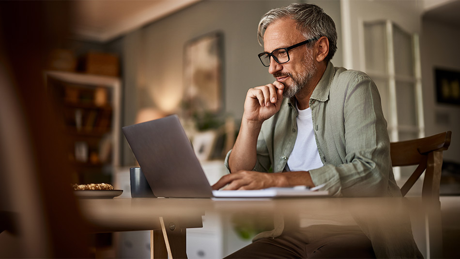Older man set at computer wondering if "Does cataract surgery hurt"